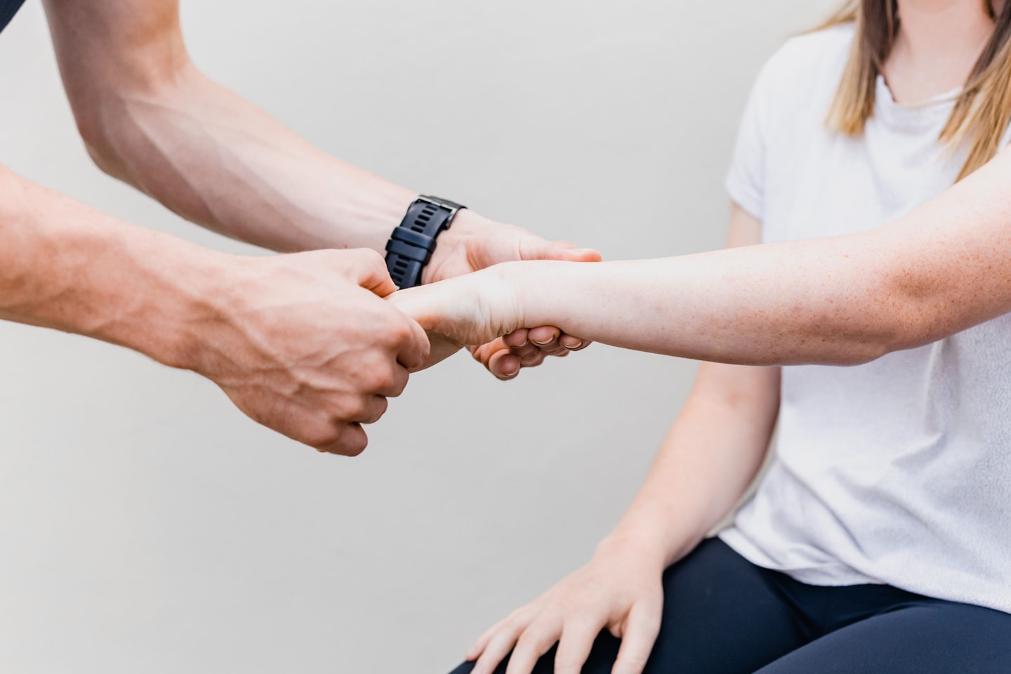 Fisioterapeuta examina el antebrazo y la muñeca de un paciente.